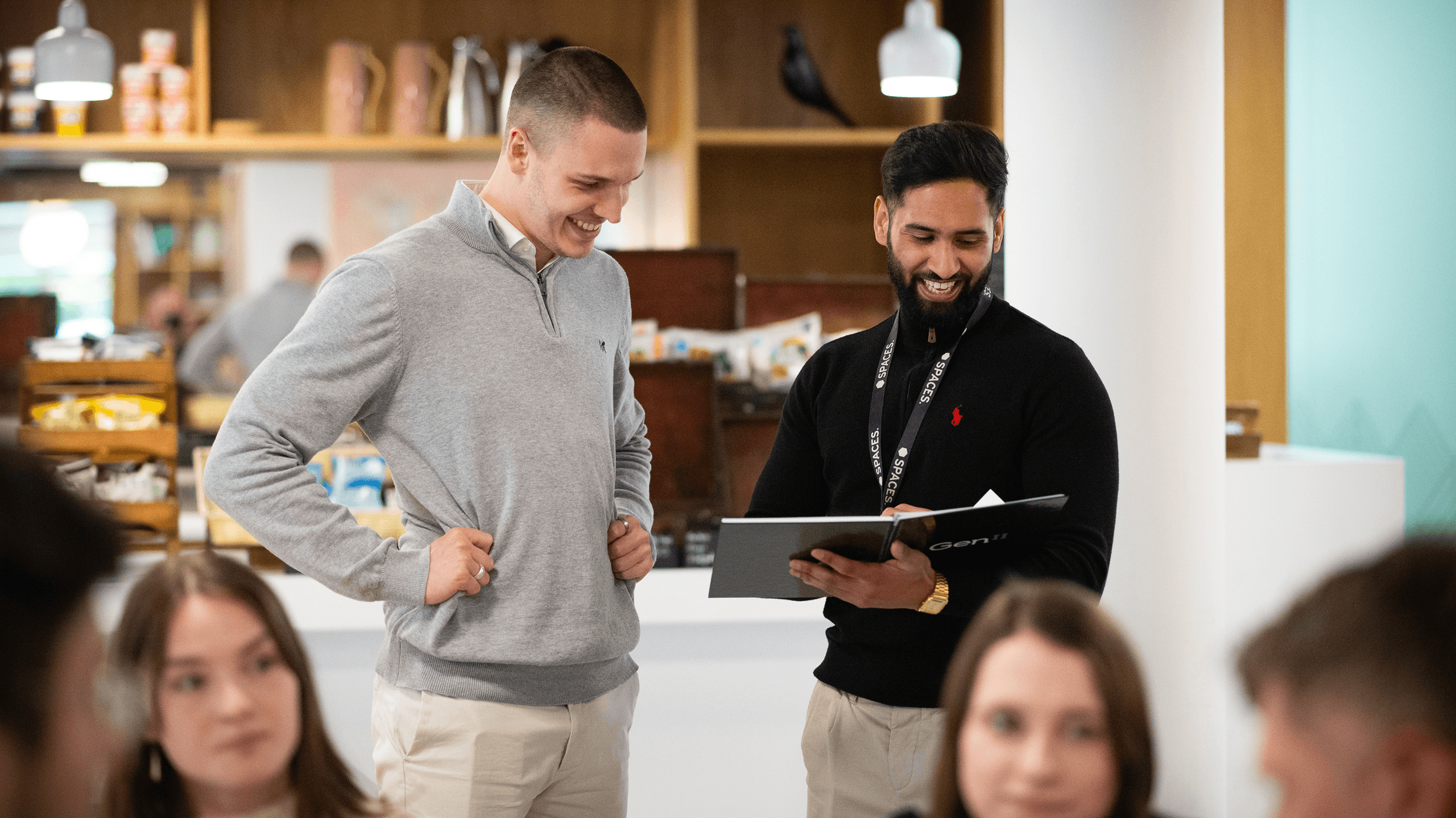 Coworkers collaborating and sharing a positive moment during a team meeting in a modern office.
