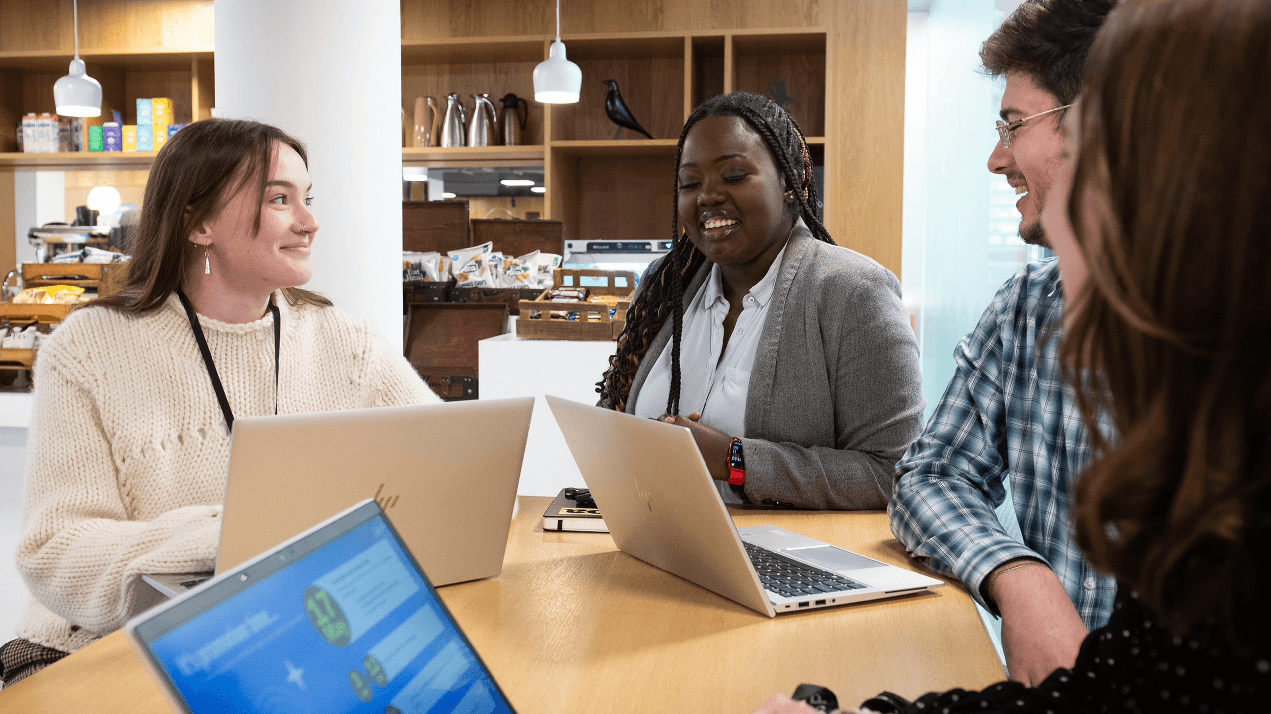 A creative, diverse team collaborating and sharing a laugh during an informal meeting.