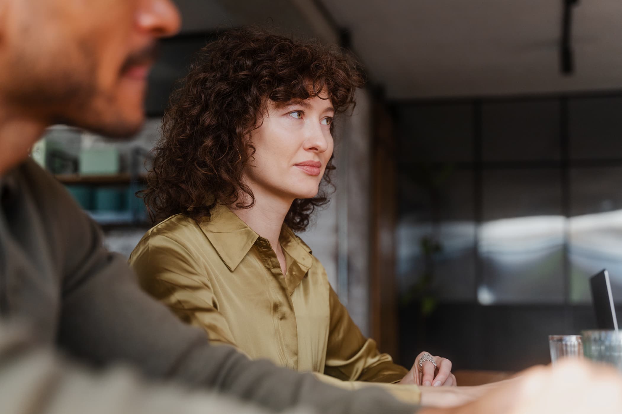 Close up of a woman in a meeting room gazing at someone across from her.