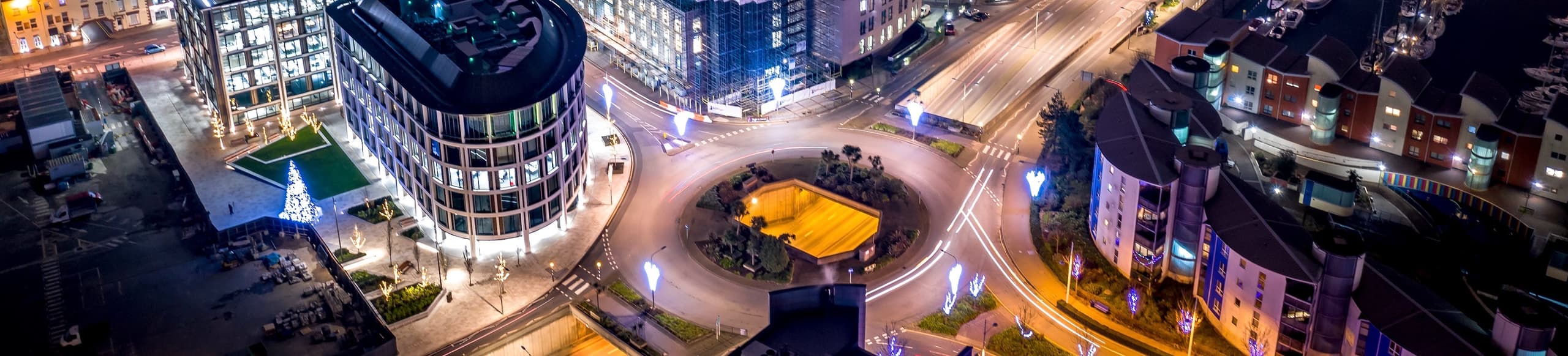 Aerial night view of a roundabout and illuminated buildings in St Helier, Jersey