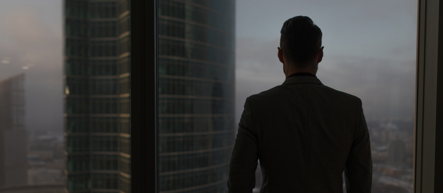 Man looking out of a skyscraper window